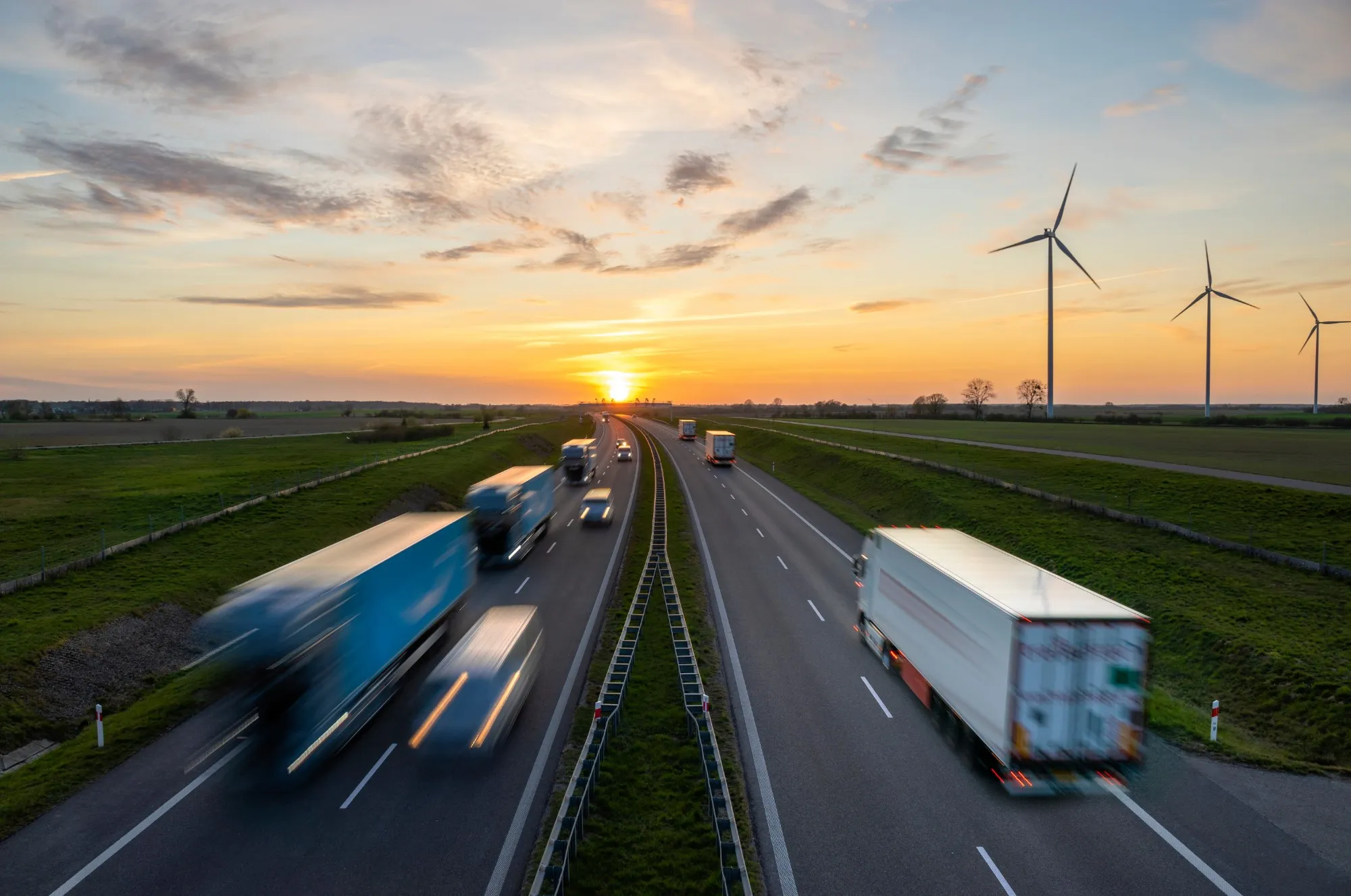 Lastbiler på motorvej i solnedgang